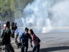 Journalists run away as Turkish riot police use tear gas to disperse protesters gathered in Diyarbakir on October 10, 2015, after twin blasts at a peace rally in Ankara left at least 86 dead. At least 86 people were killed on October 10 when two explosions ripped through groups of leftist and pro-Kurdish activists gathering for an anti-government peace rally in the Turkish capital Ankara. AFP PHOTO / ILYAS AKENGIN        (Photo credit should read ILYAS AKENGIN/AFP/Getty Images)